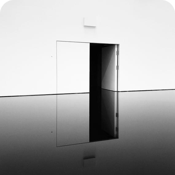 Open door on a white wall reflecting in a smooth, dark water surface.
